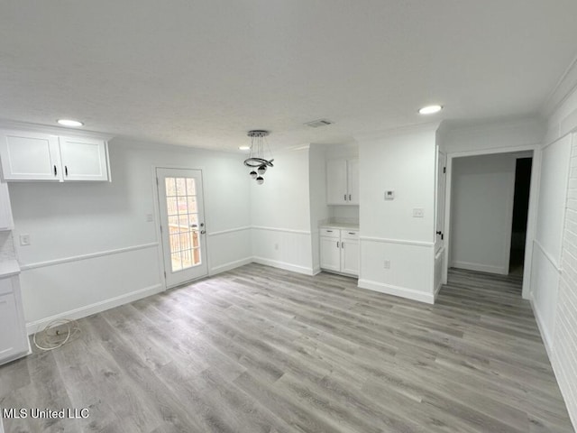 unfurnished dining area with recessed lighting, light wood-type flooring, baseboards, and crown molding