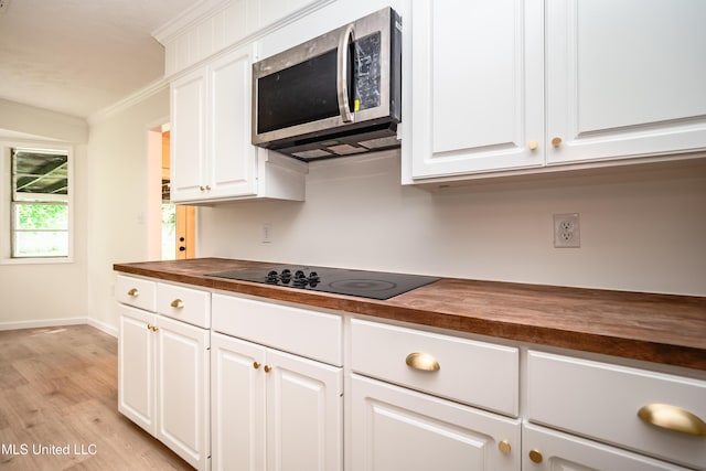 18 Crossgates Dr, Brandon, MS 39042 - kitchen featuring stainless steel microwave, butcher block counters, black electric cooktop, crown molding, and light wood finished floors