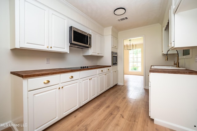 18 Crossgates Dr, Brandon, MS 39042 - kitchen featuring appliances with stainless steel finishes, butcher block counters, a sink, ornamental molding, and light wood finished floors