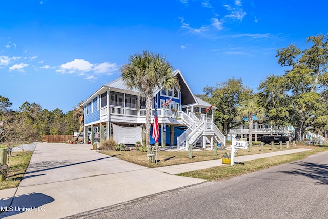 view of front of property with a sunroom, a carport, and a porch