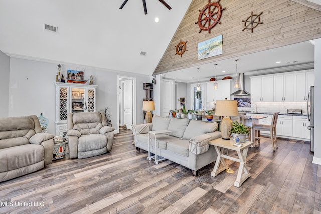 living room with ornamental molding, hardwood / wood-style flooring, high vaulted ceiling, and ceiling fan