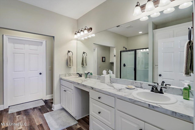 bathroom featuring hardwood / wood-style flooring, vanity, and a shower with shower door