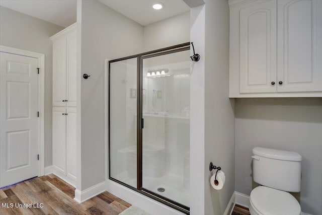 bathroom featuring toilet, wood-type flooring, and walk in shower