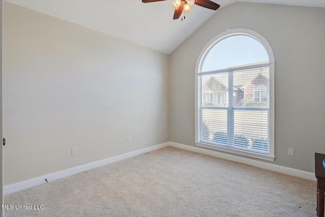 carpeted spare room with ceiling fan, plenty of natural light, and vaulted ceiling