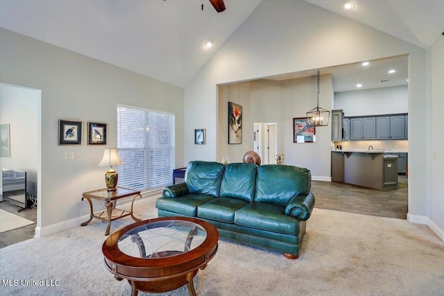 living room featuring light colored carpet, high vaulted ceiling, and ceiling fan