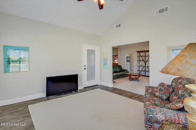 living room with ceiling fan, dark hardwood / wood-style flooring, and high vaulted ceiling