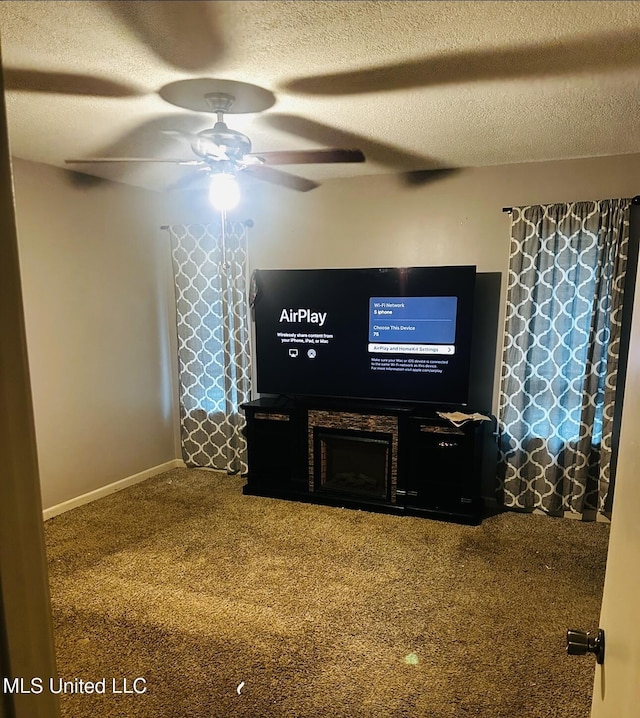 carpeted living room with baseboards, a ceiling fan, and a textured ceiling