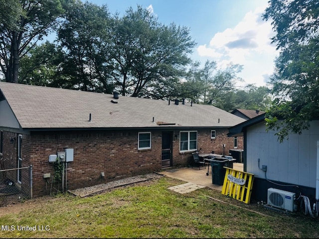 rear view of house featuring a patio, central AC, brick siding, a yard, and ac unit