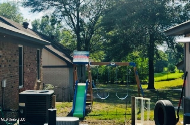 view of jungle gym with central AC unit and fence