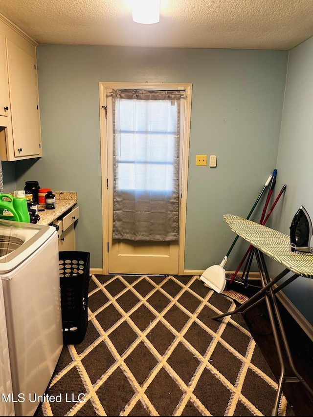 interior space with cabinet space, baseboards, a textured ceiling, and washer / dryer