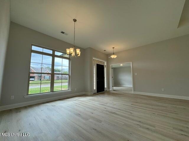 interior space with light hardwood / wood-style floors and a notable chandelier