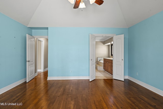 unfurnished bedroom featuring dark wood finished floors, ceiling fan, baseboards, and lofted ceiling