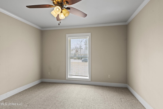 carpeted spare room with a ceiling fan, baseboards, and ornamental molding
