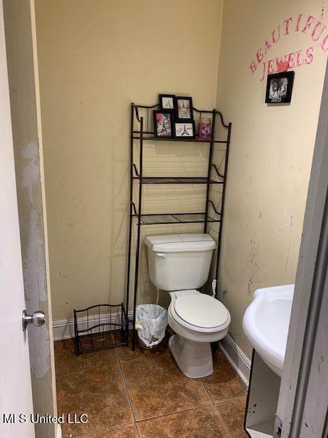 1509 Eastwood Rd, Natchez, MS 39120 - bathroom featuring toilet, tile patterned floors, baseboards, and a sink