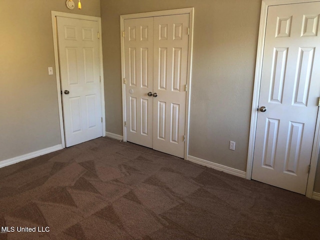 unfurnished bedroom featuring a closet and dark colored carpet