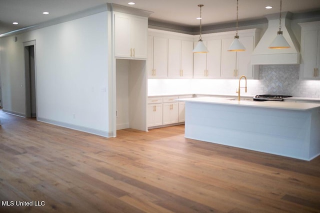 256 Arbor Trl, Brandon, MS 39047 - kitchen with premium range hood, a sink, light wood finished floors, a center island with sink, and backsplash