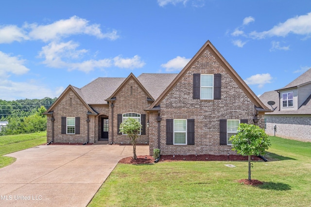275 Magnolia Gardens Dr, Hernando, MS 38632 - view of front of home featuring brick siding, a front yard, a shingled roof, and driveway