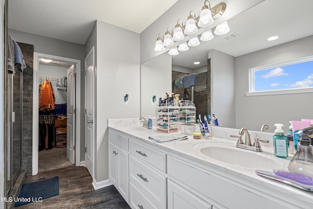 275 Magnolia Gardens Dr, Hernando, MS 38632 - full bathroom featuring double vanity, a shower stall, a walk in closet, and wood finished floors