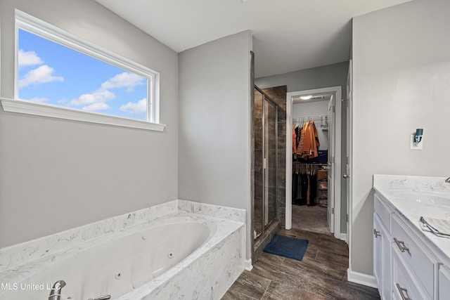 275 Magnolia Gardens Dr, Hernando, MS 38632 - full bathroom featuring a stall shower, a whirlpool tub, vanity, a walk in closet, and wood finished floors