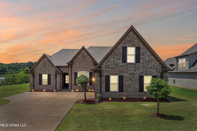 275 Magnolia Gardens Dr, Hernando, MS 38632 - french country inspired facade featuring brick siding, a front lawn, and concrete driveway