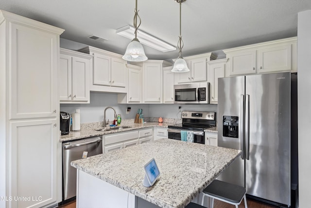 275 Magnolia Gardens Dr, Hernando, MS 38632 - kitchen with stainless steel appliances, white cabinetry, a breakfast bar area, and pendant lighting