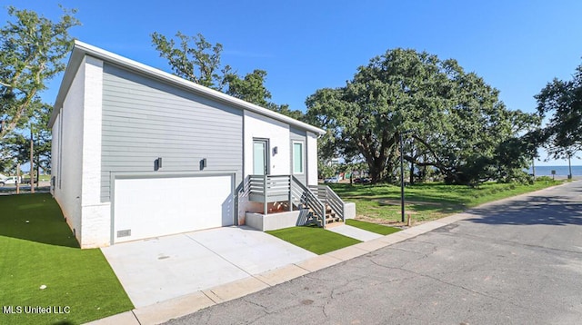 view of front of house featuring a garage and a front lawn