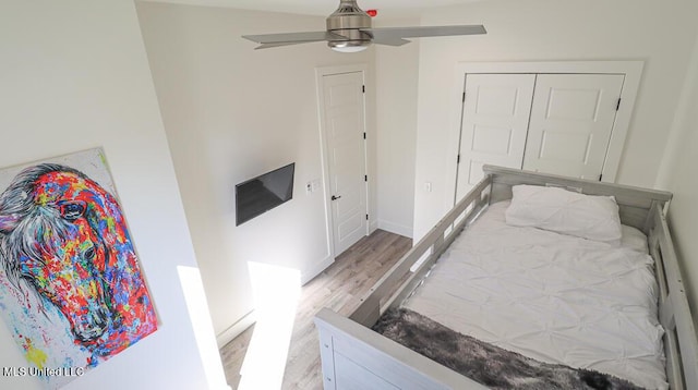 bedroom with ceiling fan, wood-type flooring, and a closet