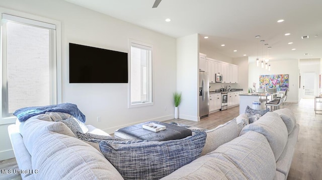 living room with light wood-type flooring and ceiling fan