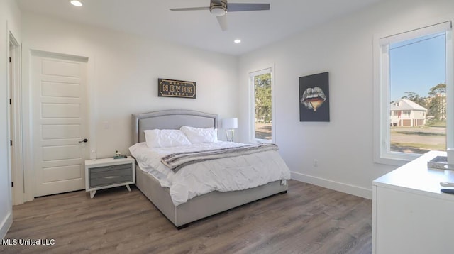 bedroom with dark hardwood / wood-style flooring and ceiling fan