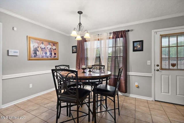 dining area featuring light tile patterned floors, a chandelier, ornamental molding, and baseboards