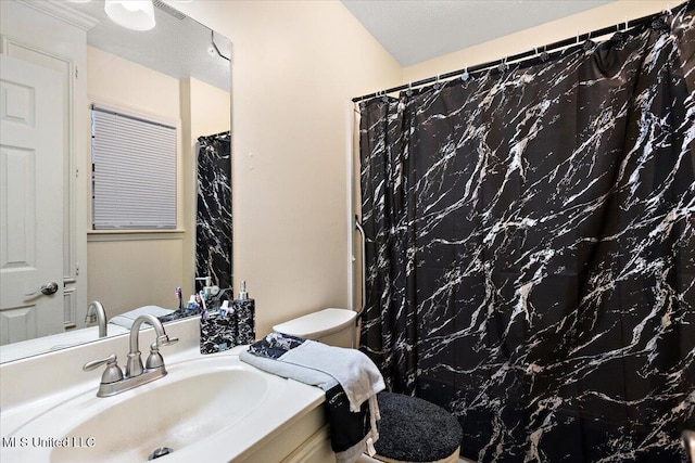 bathroom with toilet, vanity, and a shower with shower curtain