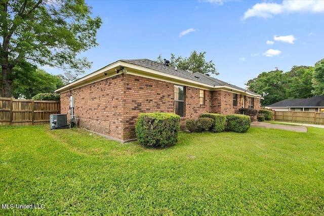 view of side of property featuring brick siding, central AC unit, and a patio area