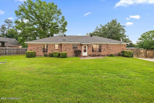 rear view of property featuring a chimney, brick siding, and a patio