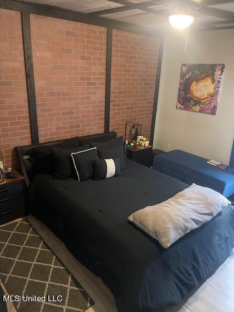 bedroom featuring brick wall