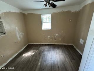 empty room featuring dark wood-type flooring and ceiling fan