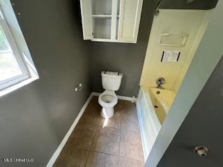 bathroom with tile patterned floors, toilet, and shower / bathtub combination