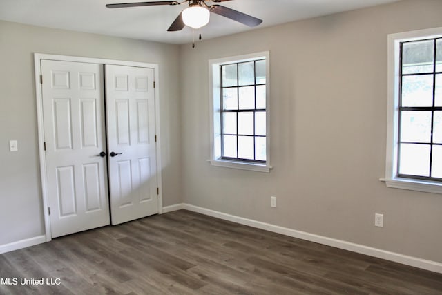 unfurnished bedroom with a closet, ceiling fan, and dark hardwood / wood-style flooring