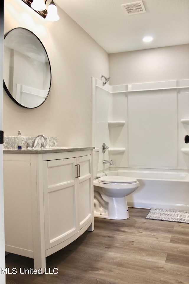 full bathroom featuring bathtub / shower combination, hardwood / wood-style floors, toilet, and vanity