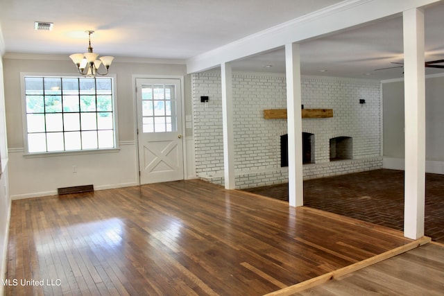 interior space featuring crown molding, hardwood / wood-style flooring, and a brick fireplace