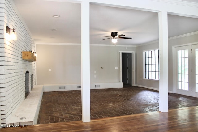 unfurnished living room featuring ceiling fan, ornamental molding, dark hardwood / wood-style flooring, and a brick fireplace