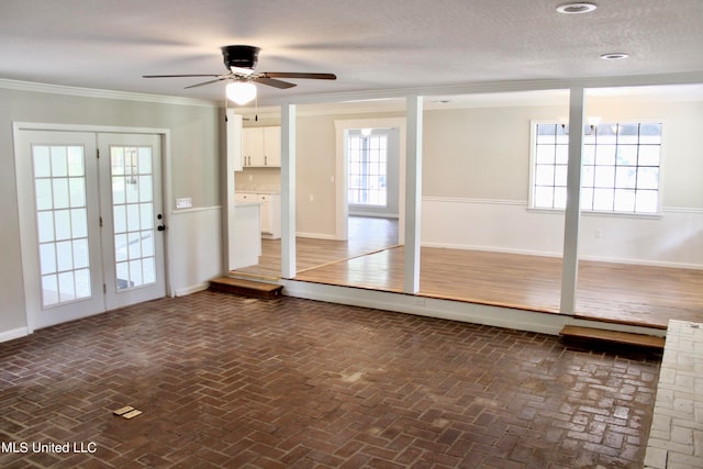 interior space featuring crown molding, a textured ceiling, plenty of natural light, and ceiling fan