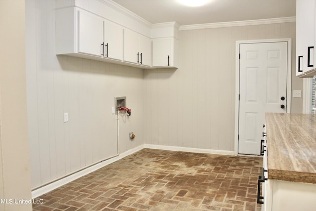 laundry area featuring wood walls, crown molding, washer hookup, and cabinets