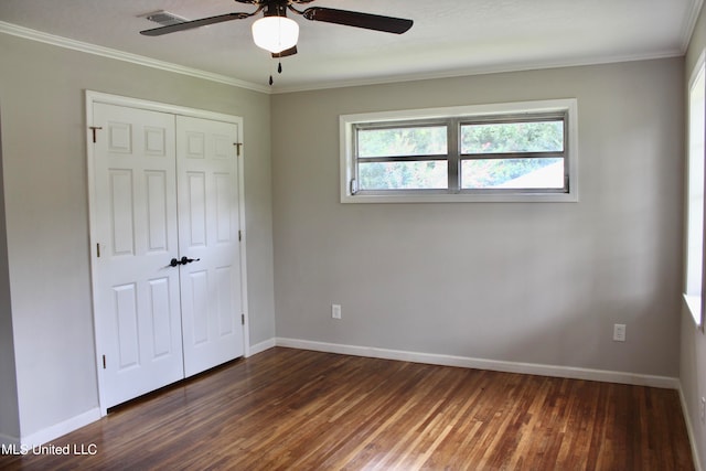 unfurnished bedroom featuring a closet, ornamental molding, dark wood-type flooring, and ceiling fan