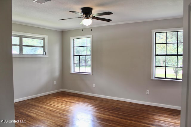 unfurnished room with crown molding, ceiling fan, plenty of natural light, and dark hardwood / wood-style flooring