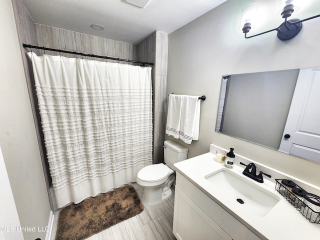 bathroom with vanity, toilet, and walk in shower