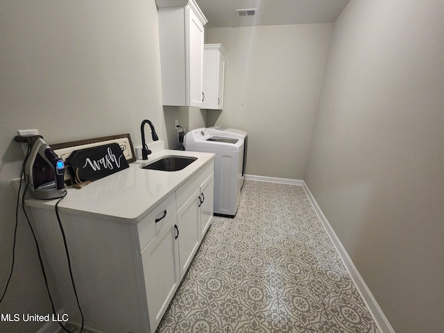 laundry area with sink, washing machine and dryer, and cabinets