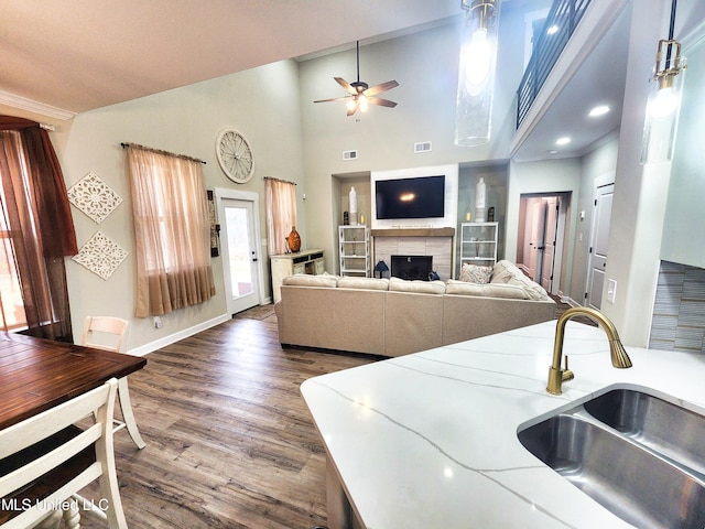 kitchen with ornamental molding, sink, dark wood-type flooring, and ceiling fan