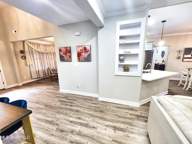 interior space with crown molding, hardwood / wood-style flooring, and built in shelves