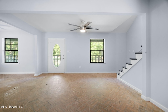 entryway with baseboards, stairs, and ceiling fan