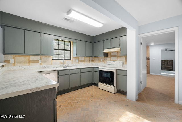 kitchen featuring backsplash, visible vents, white range with electric cooktop, a sink, and under cabinet range hood